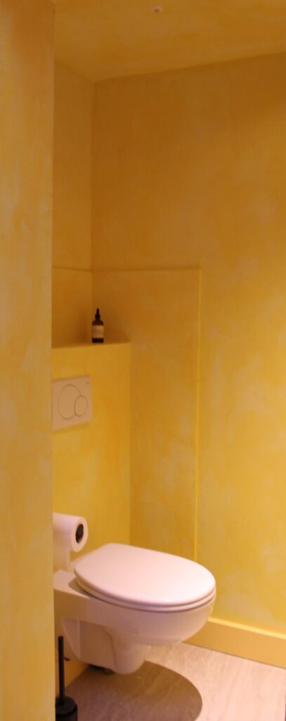 Microtopping toiletruimte met opgeschilderde gele patine